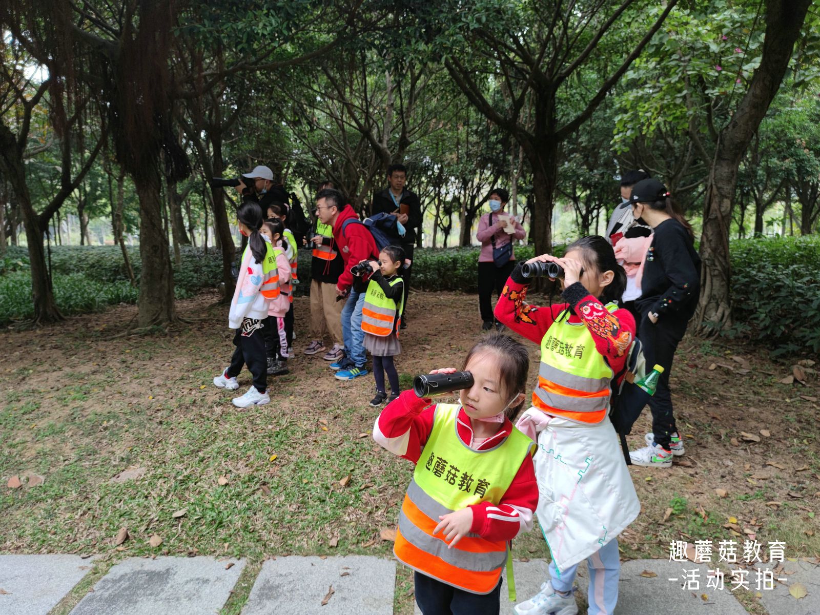 A child looking through binoculars at the trees