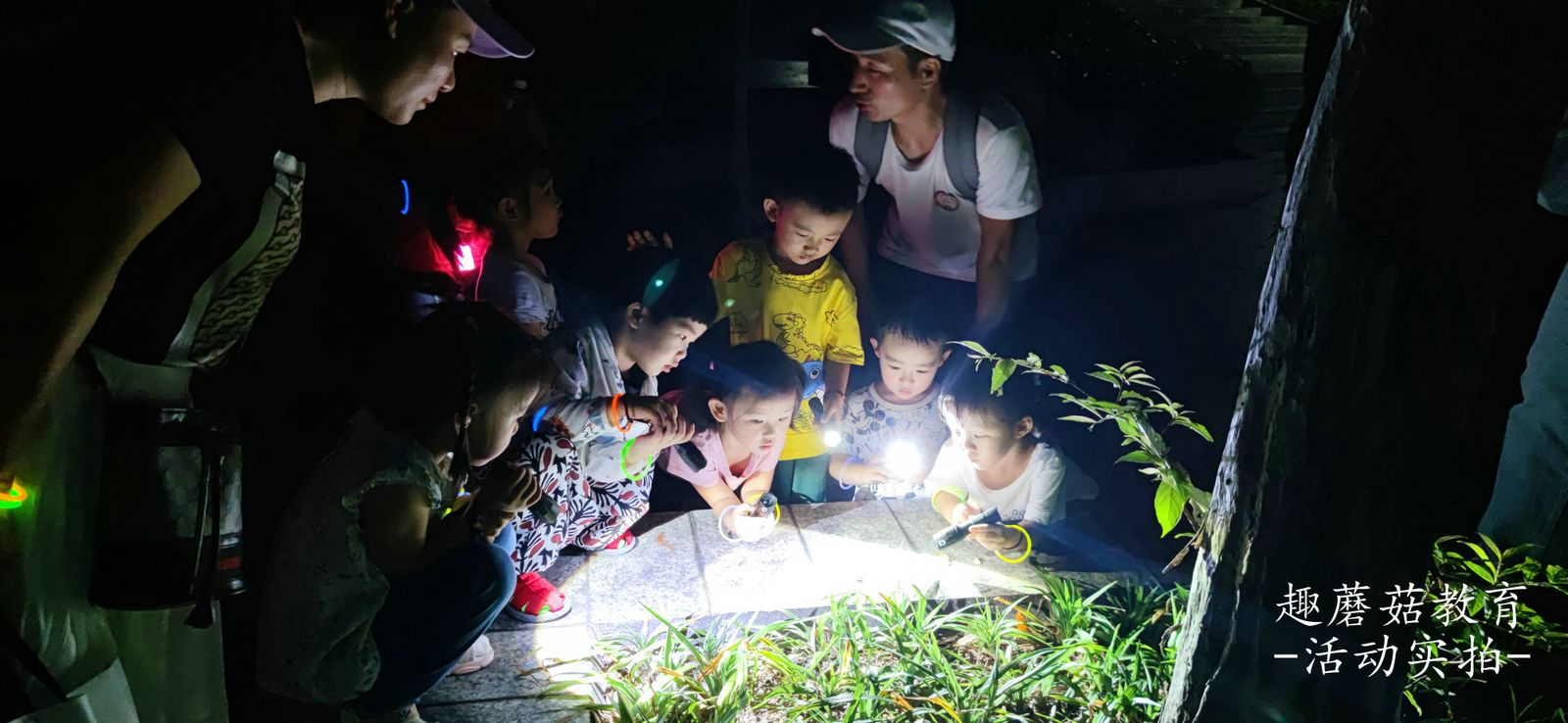 Kids crouching to look at something on the ground at night