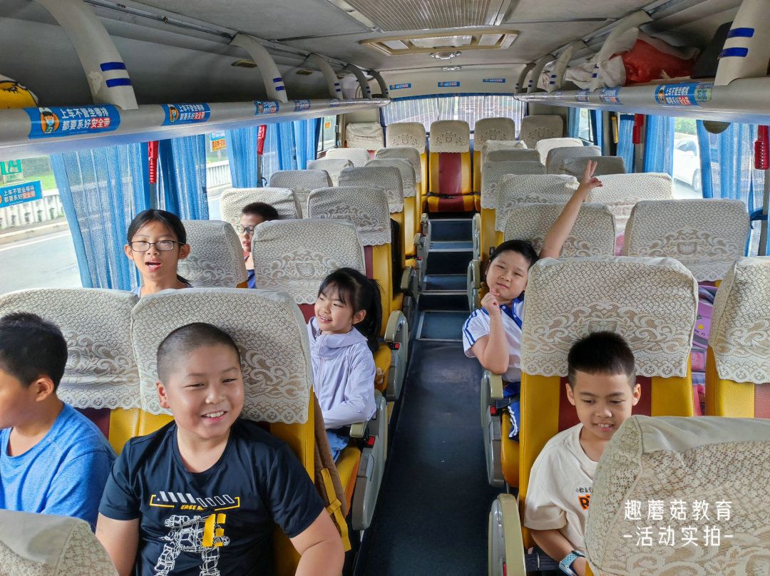 Kids on the camp bus waving to the camera